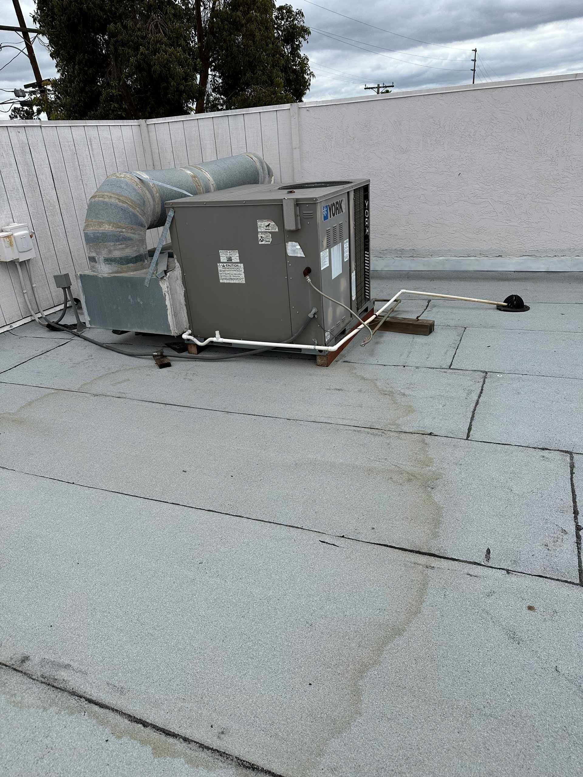 An air conditioner is sitting on the roof of a building.