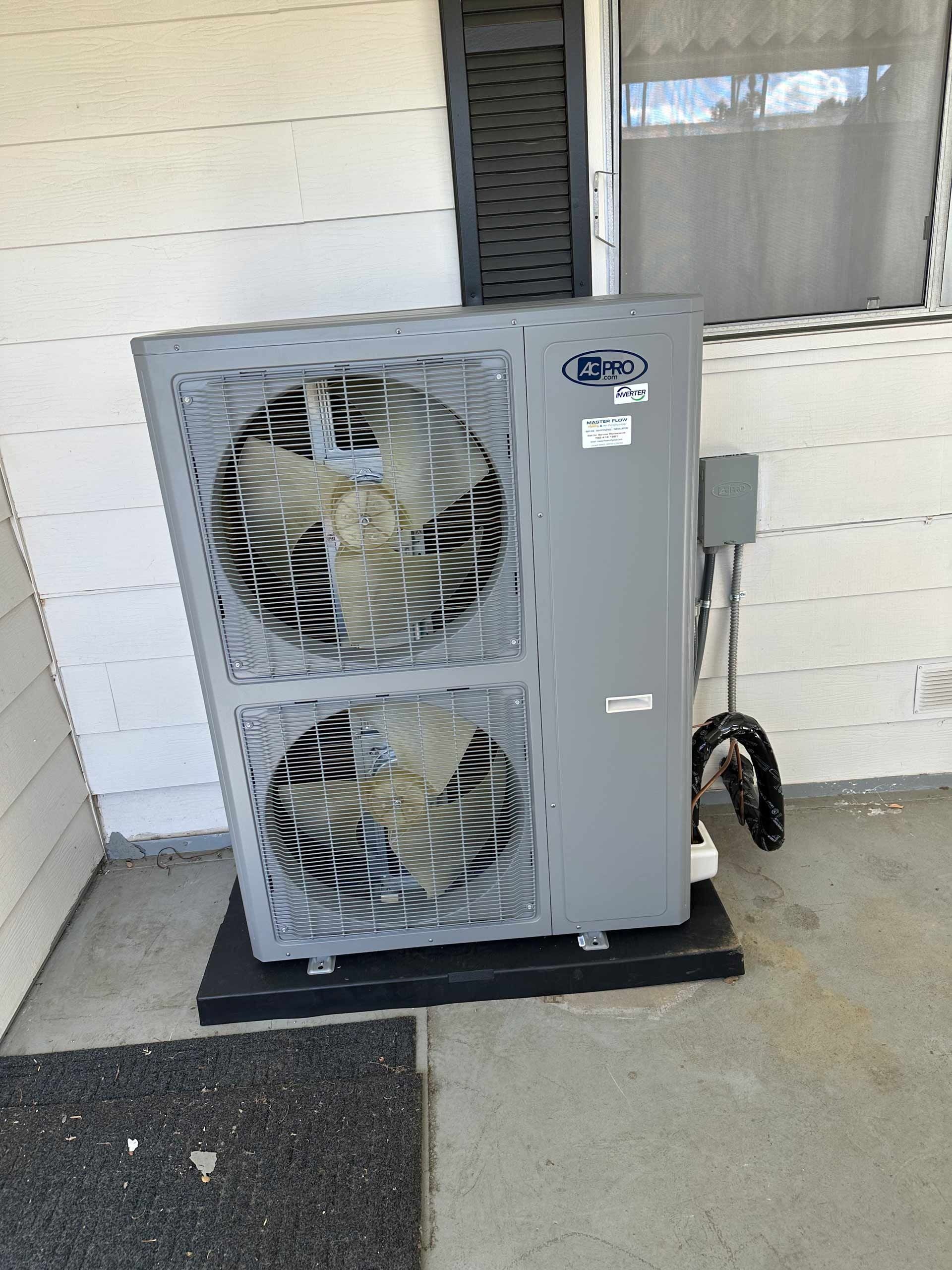 A large air conditioner is sitting on the side of a building.