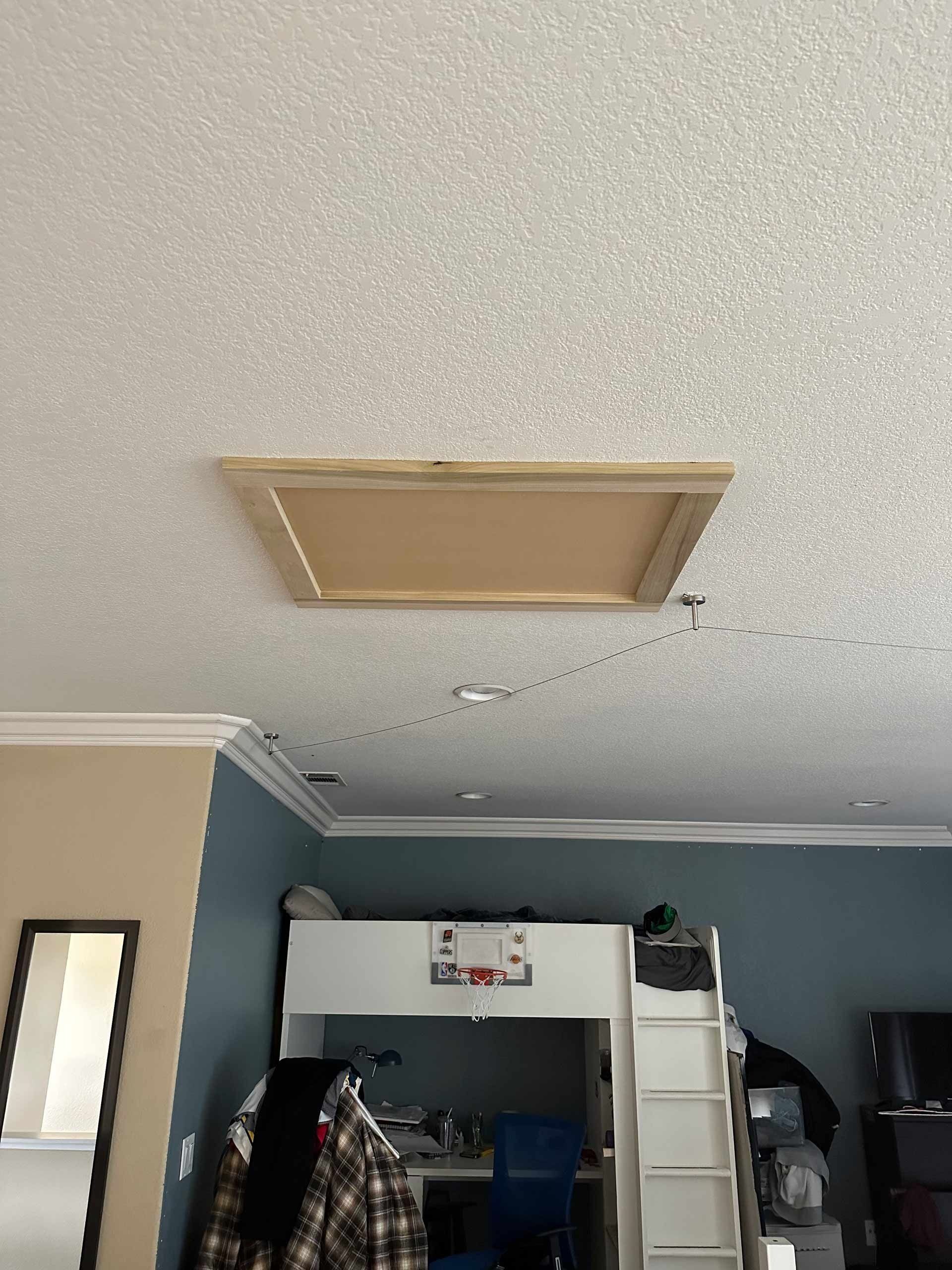 A bedroom with a loft bed and a mirror.