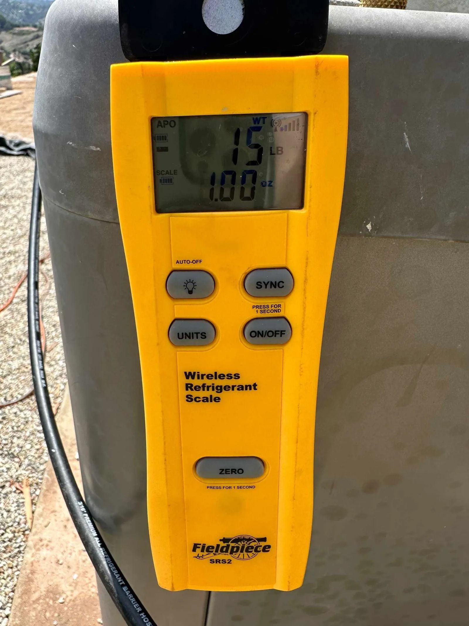 A yellow thermometer is sitting on top of a plastic container.