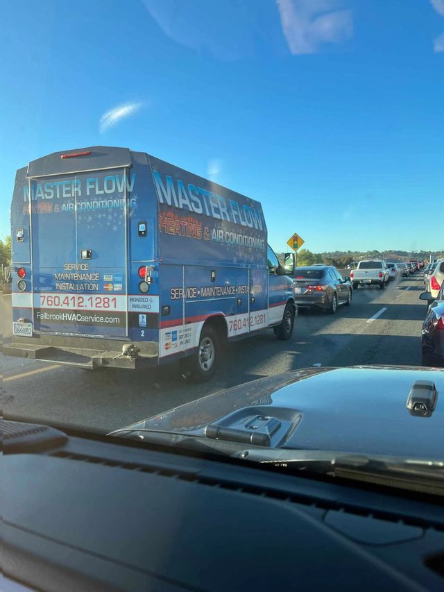 A blue van that says master flush is driving down a highway