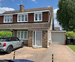 A car is parked in front of a house with a garage.