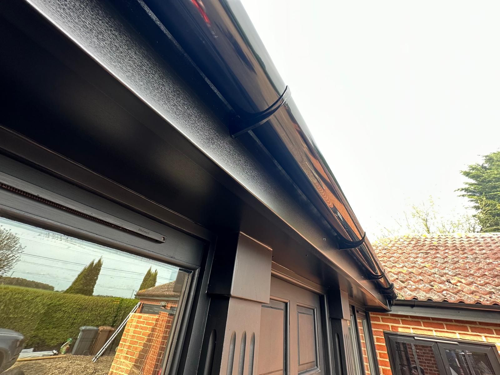 A close up of a black gutter on the side of a house.