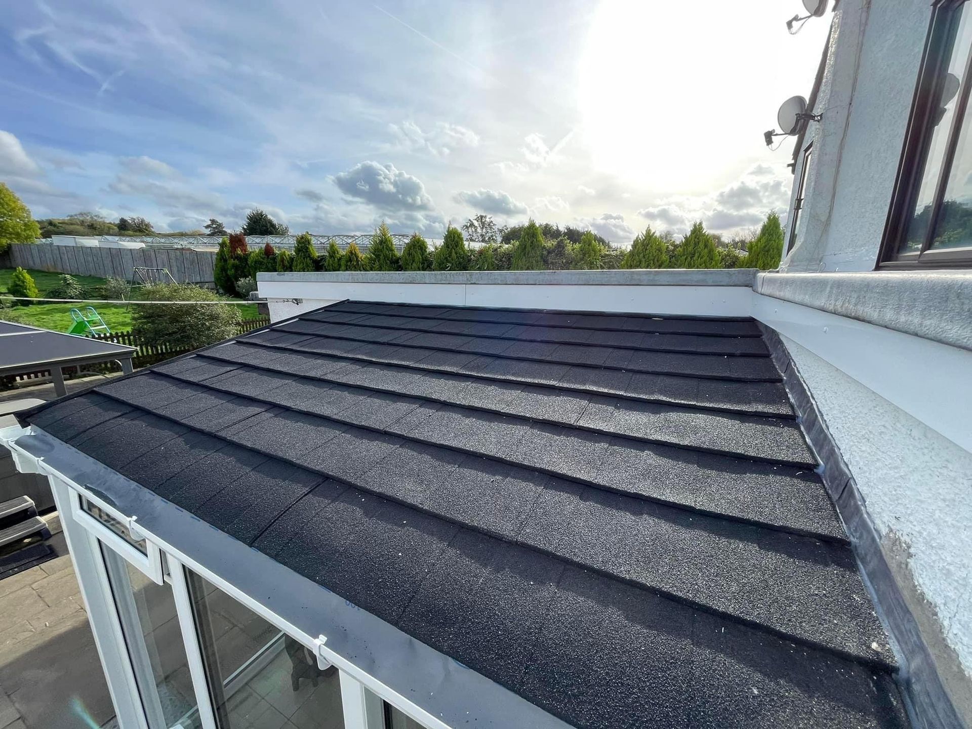 The roof of a house with a black roof and a white trim.