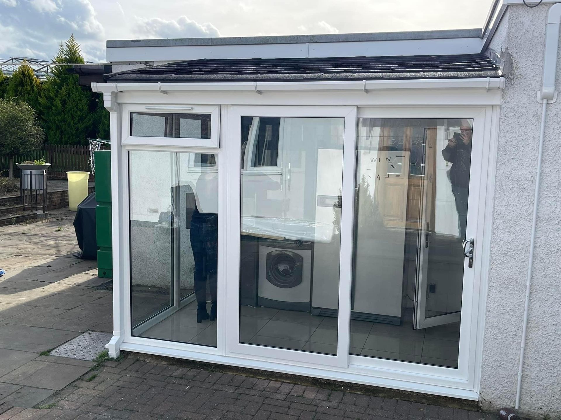 A white house with a sliding glass door and a washing machine.