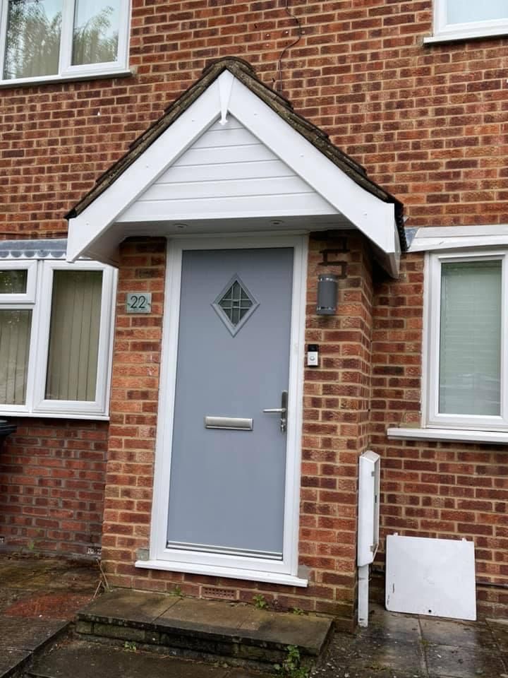 A brick house with a gray door and white windows