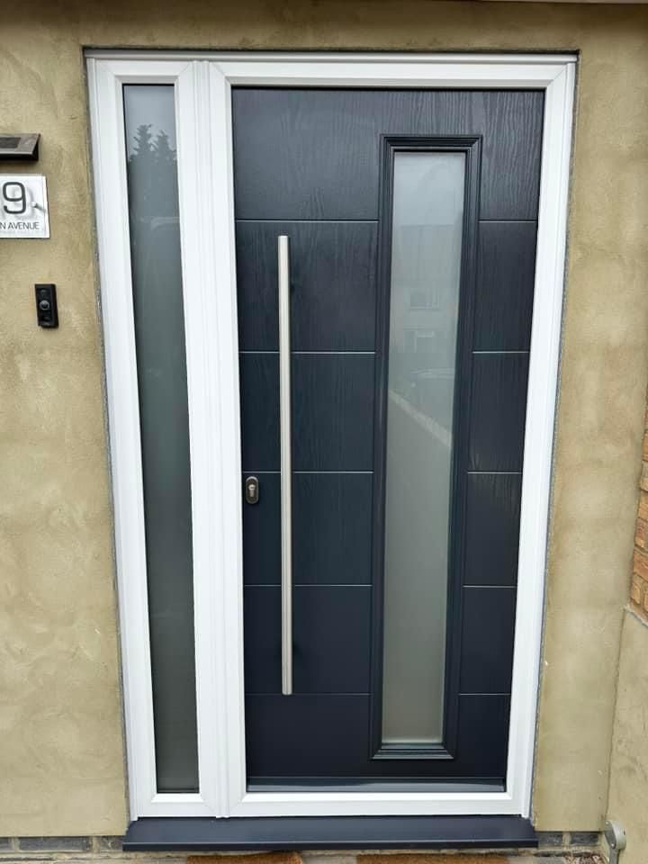 A black front door with a white frame and a stainless steel handle.