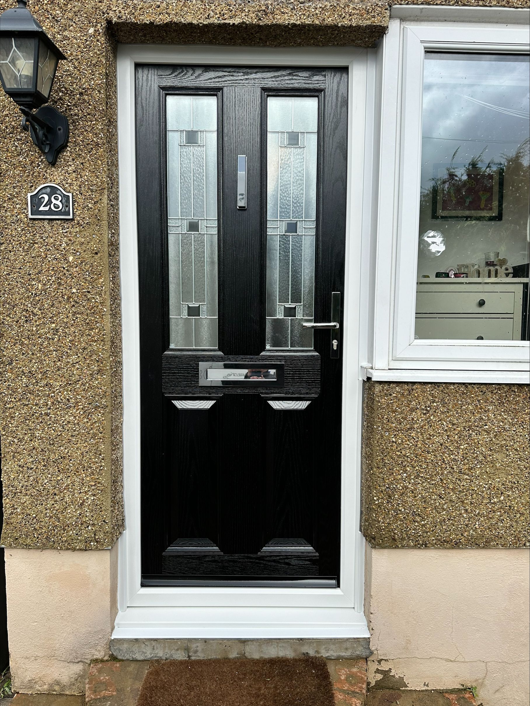 A black door with a white trim is on the front of a house.