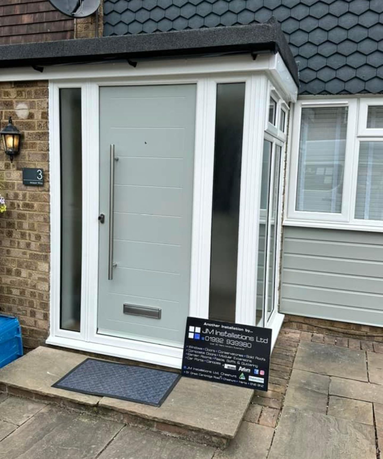 The front door of a house with a sign in front of it.