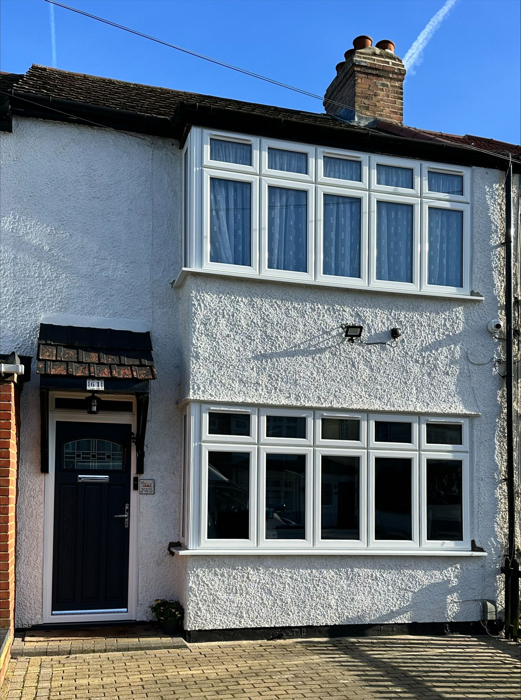 A white house with a black door and many windows