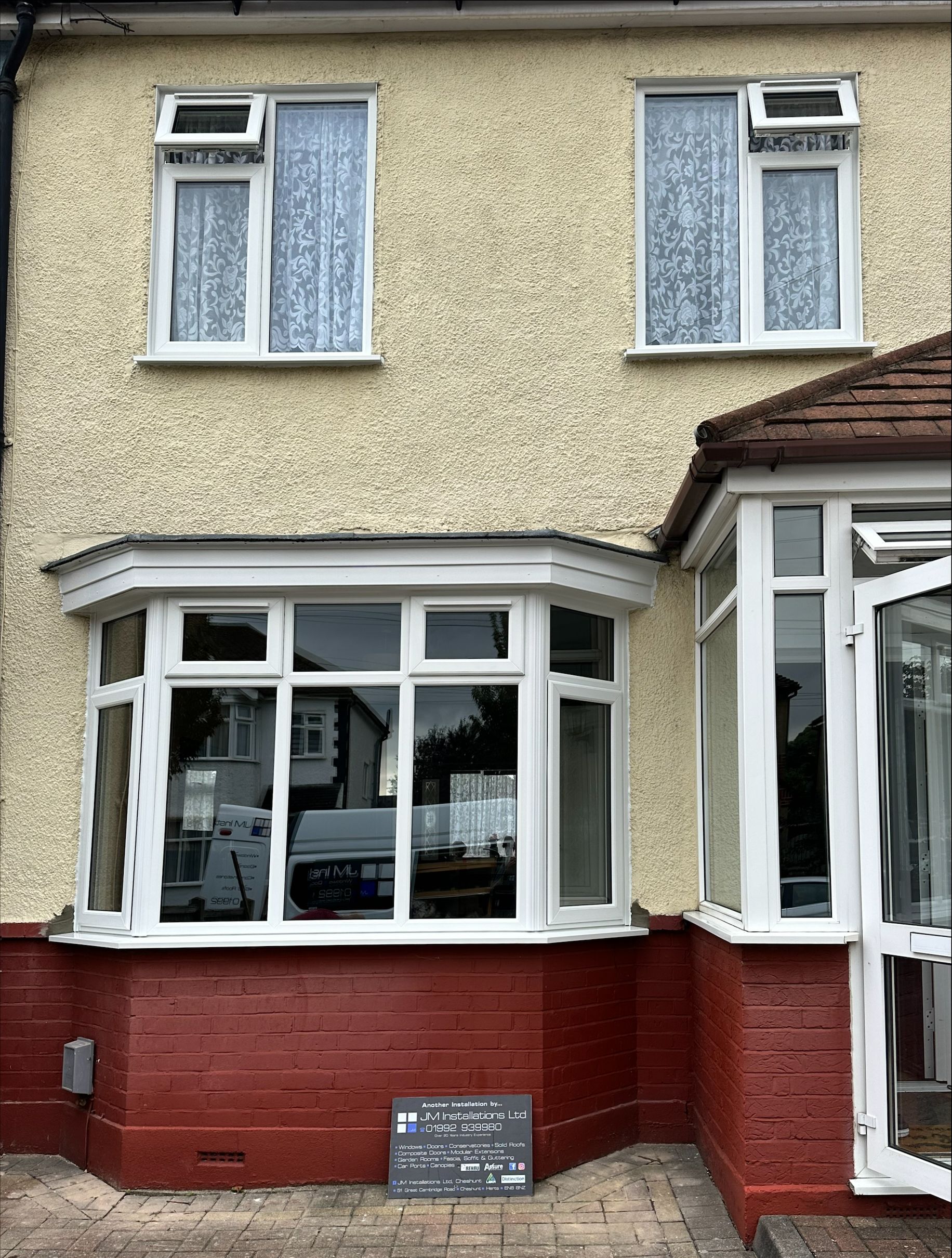A house with a large bay window and a conservatory.