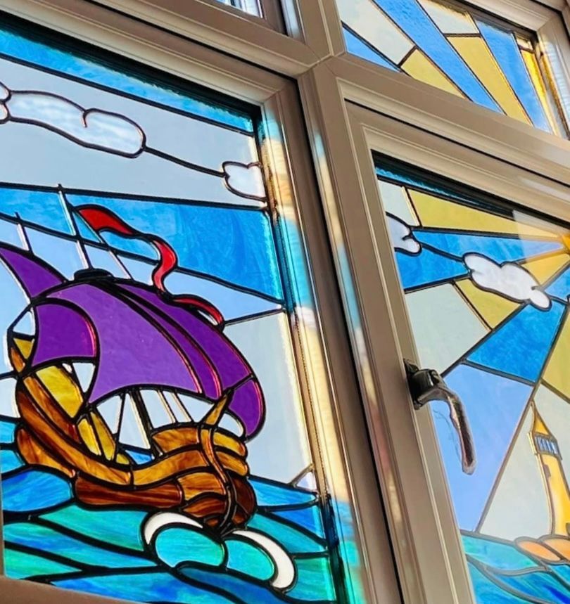 A stained glass window shows a boat in the ocean