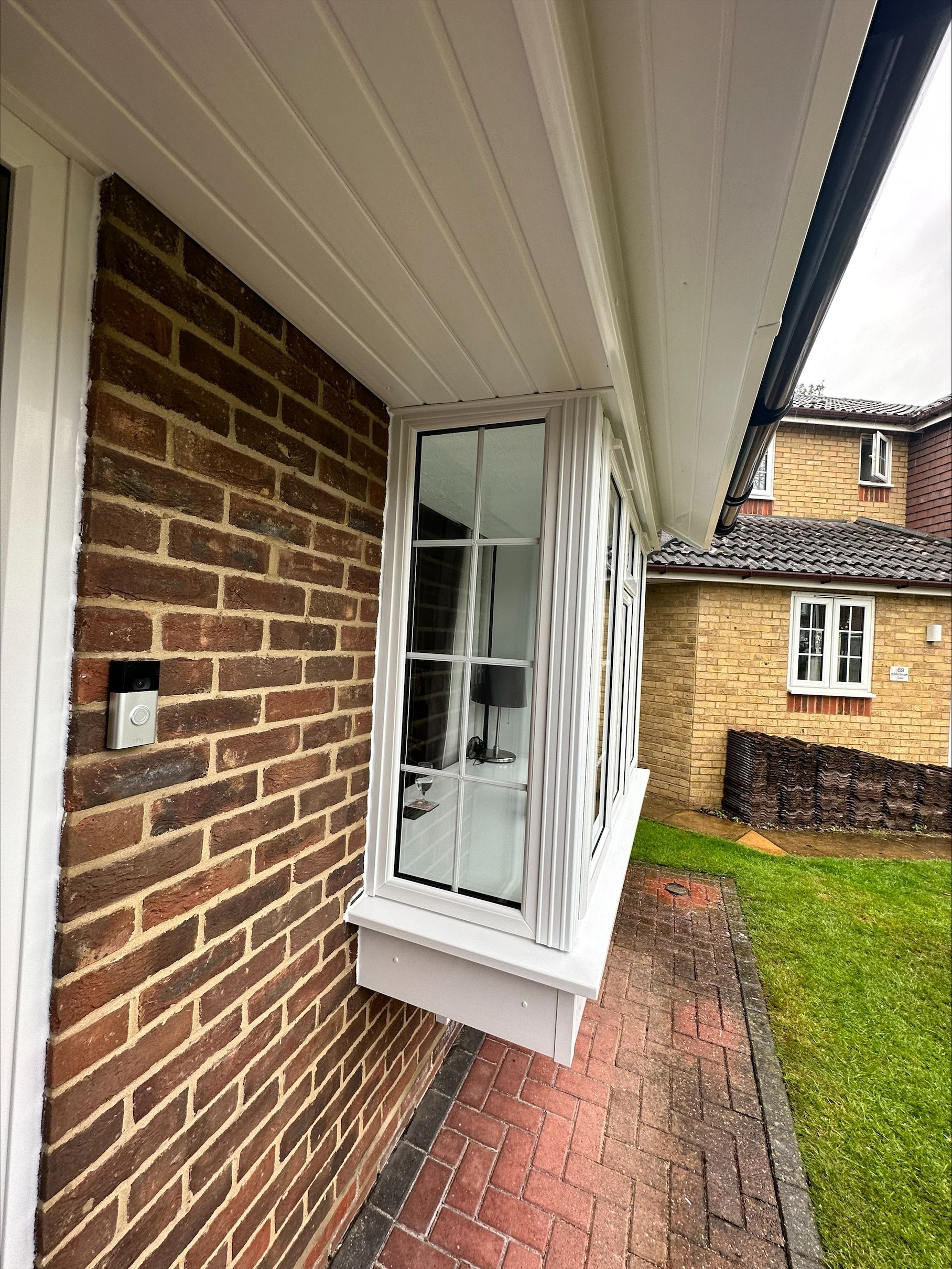 A brick house with a large window on the side of it.