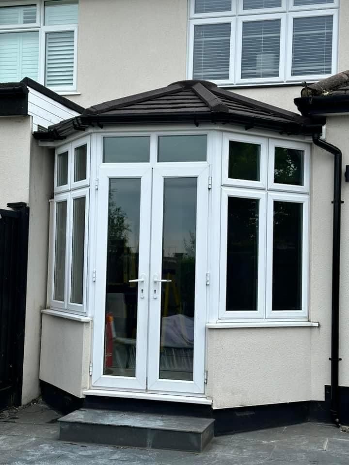 A white house with a bay window and a roof