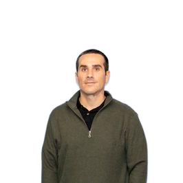 Man in olive green sweater, black shirt, standing against a blue background.