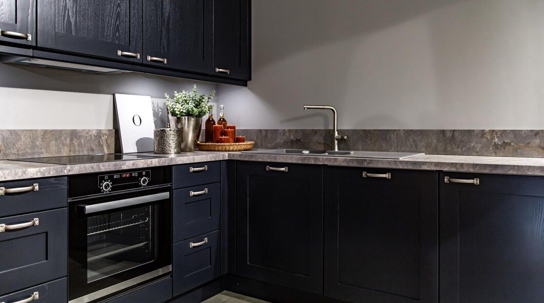 A kitchen with blue cabinets , black appliances , a sink , and a stove.