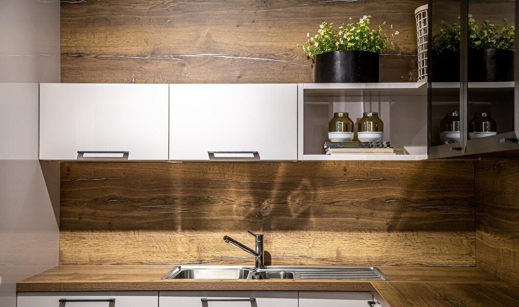 A kitchen with a sink , cabinets , and a wooden wall.