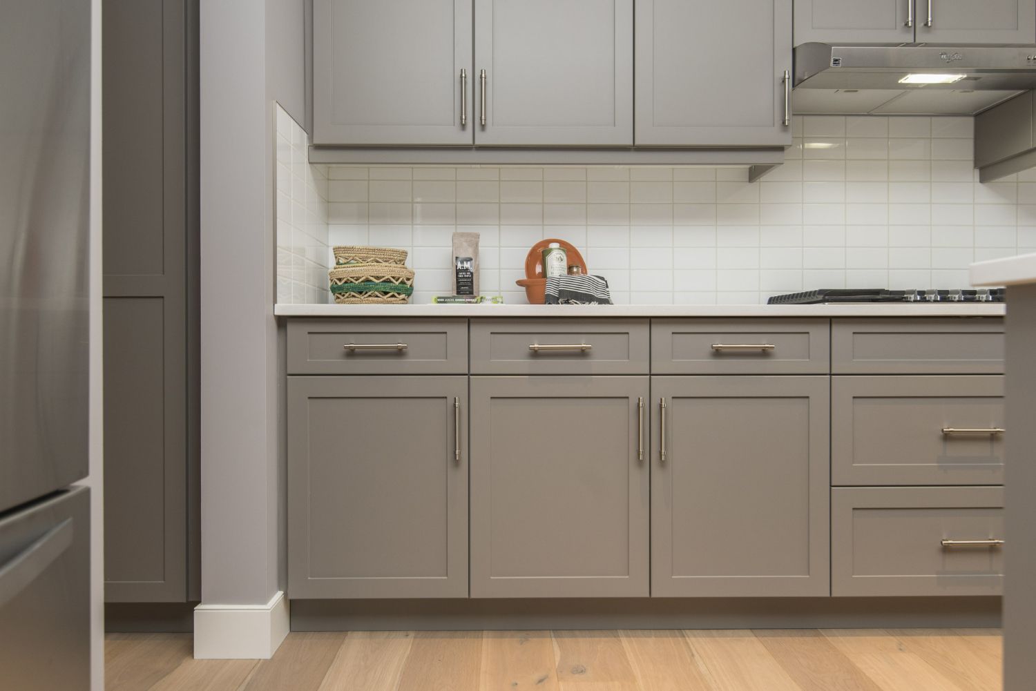 A kitchen with gray cabinets and stainless steel appliances.