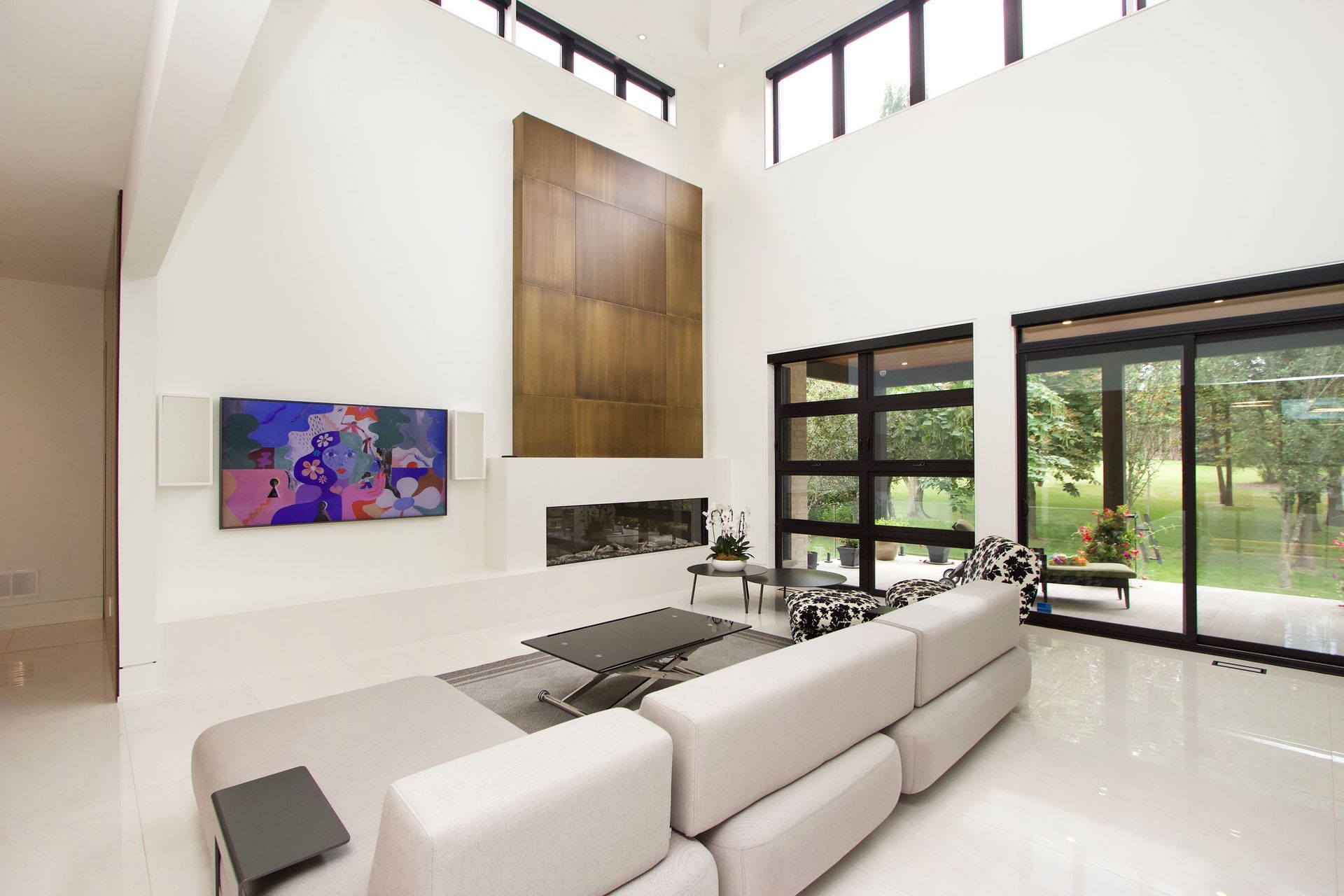 Modern living room with high ceilings, white walls, and a large sectional sofa.
