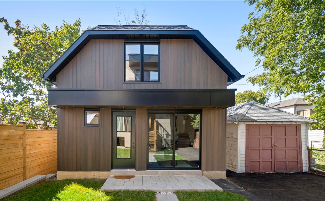 A small house with a garage in the backyard.