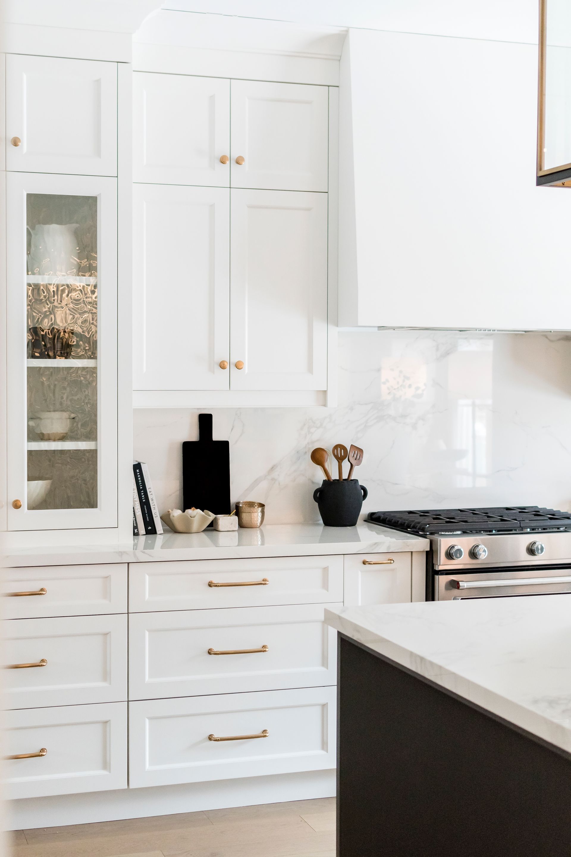 A kitchen with white cabinets and a stove top oven