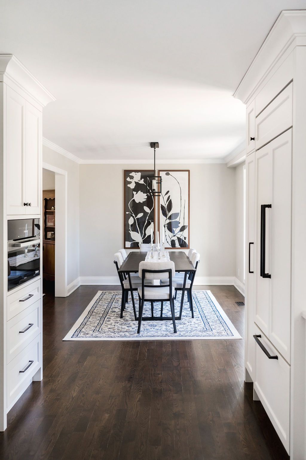 A dining room with a table and chairs and a rug on the floor