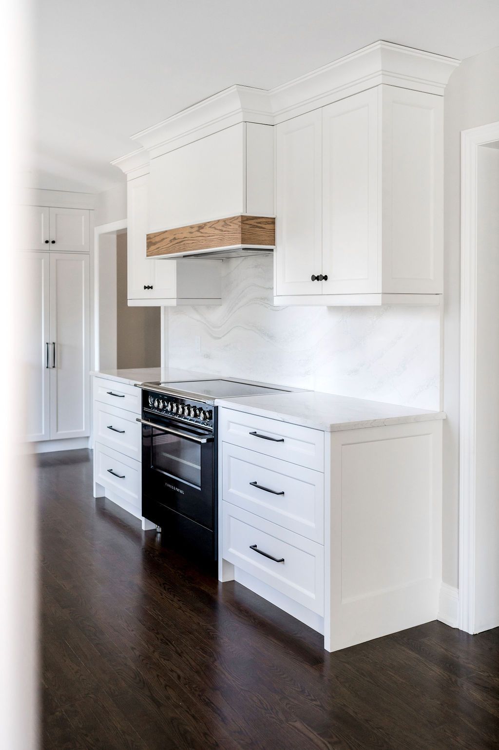 A kitchen with white cabinets and a black stove
