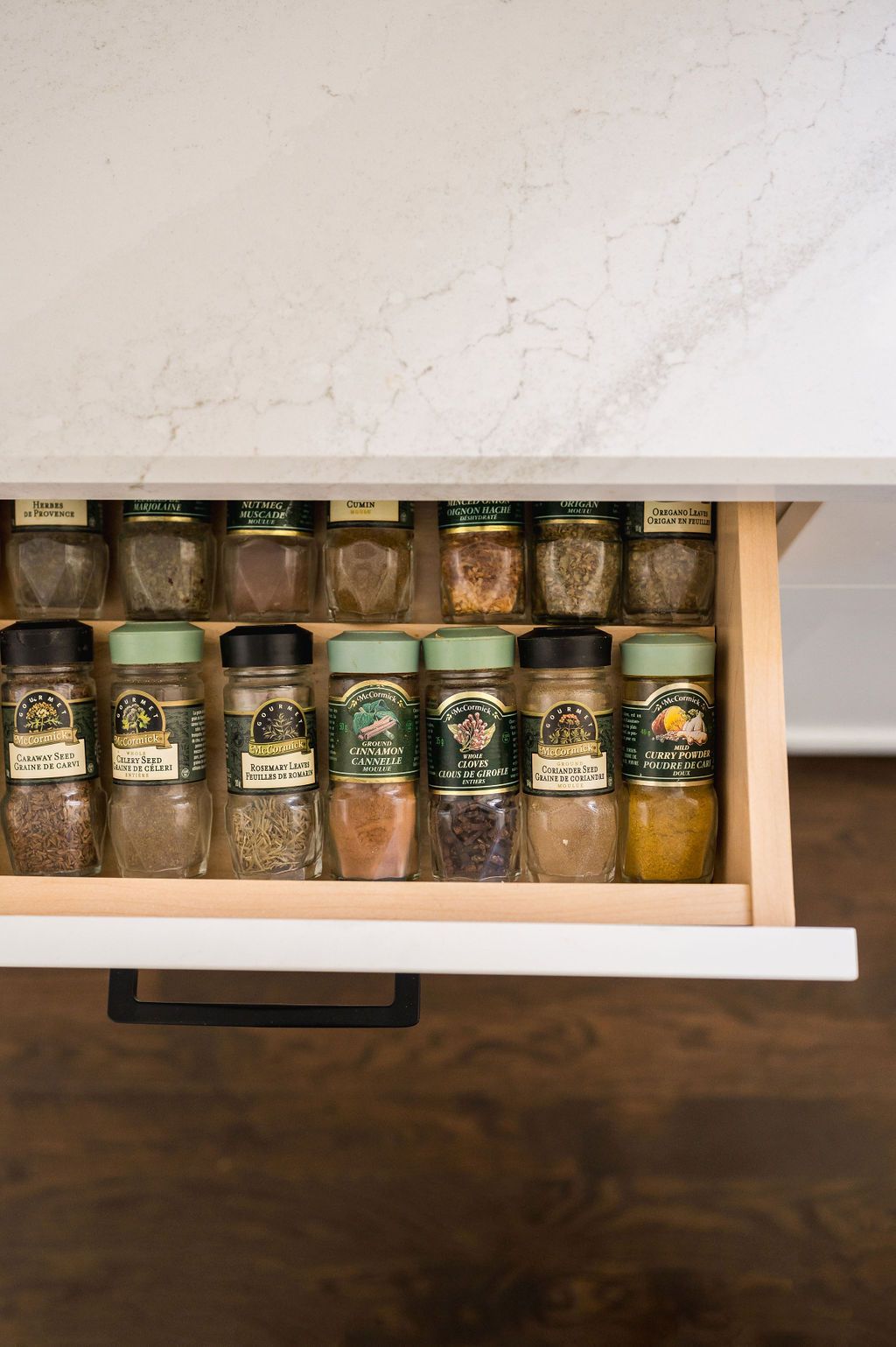 A spice drawer filled with lots of jars of spices.