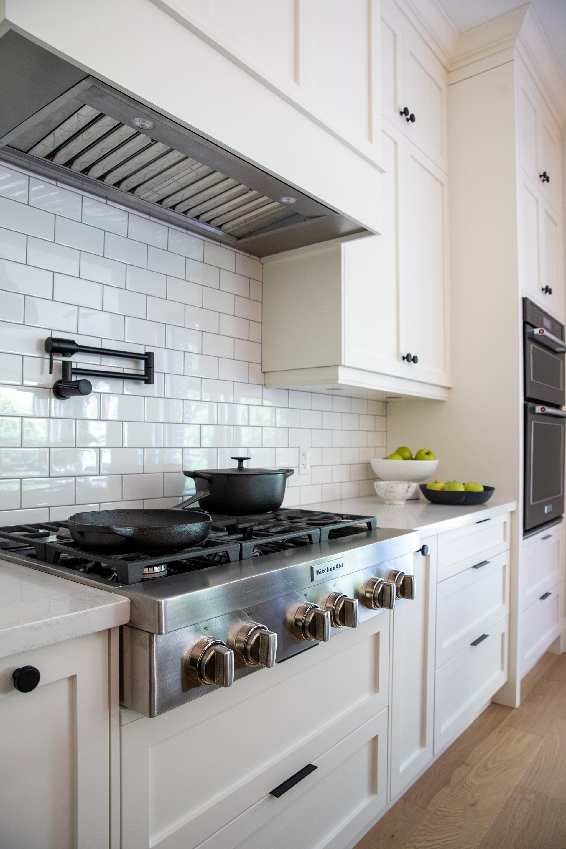A kitchen with white cabinets and a stove top oven.