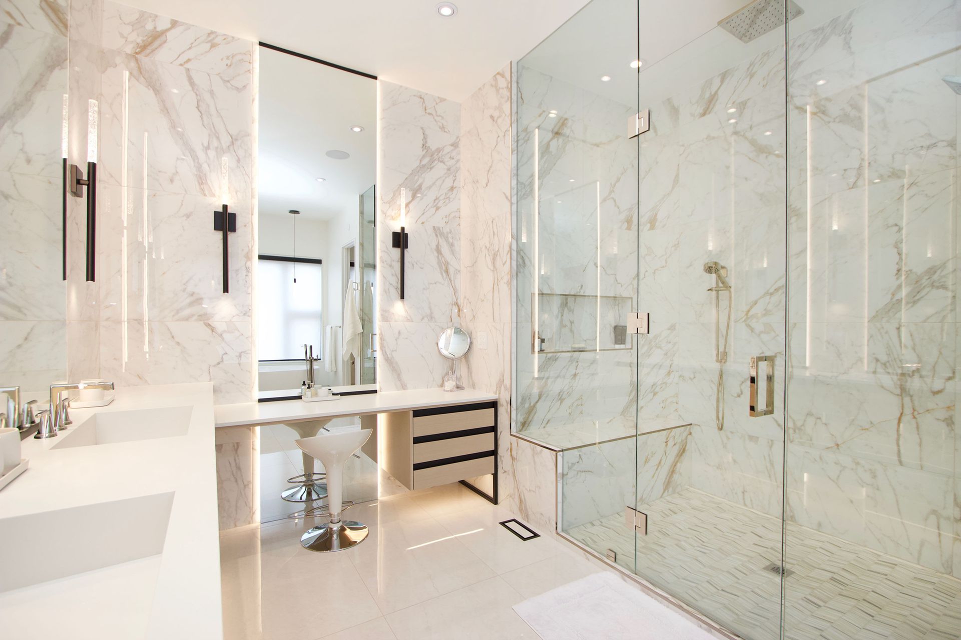 A bathroom with marble walls and a walk in shower.