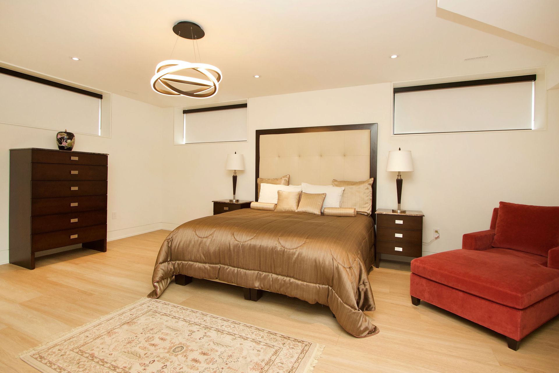 A bedroom with a large bed and a red chair