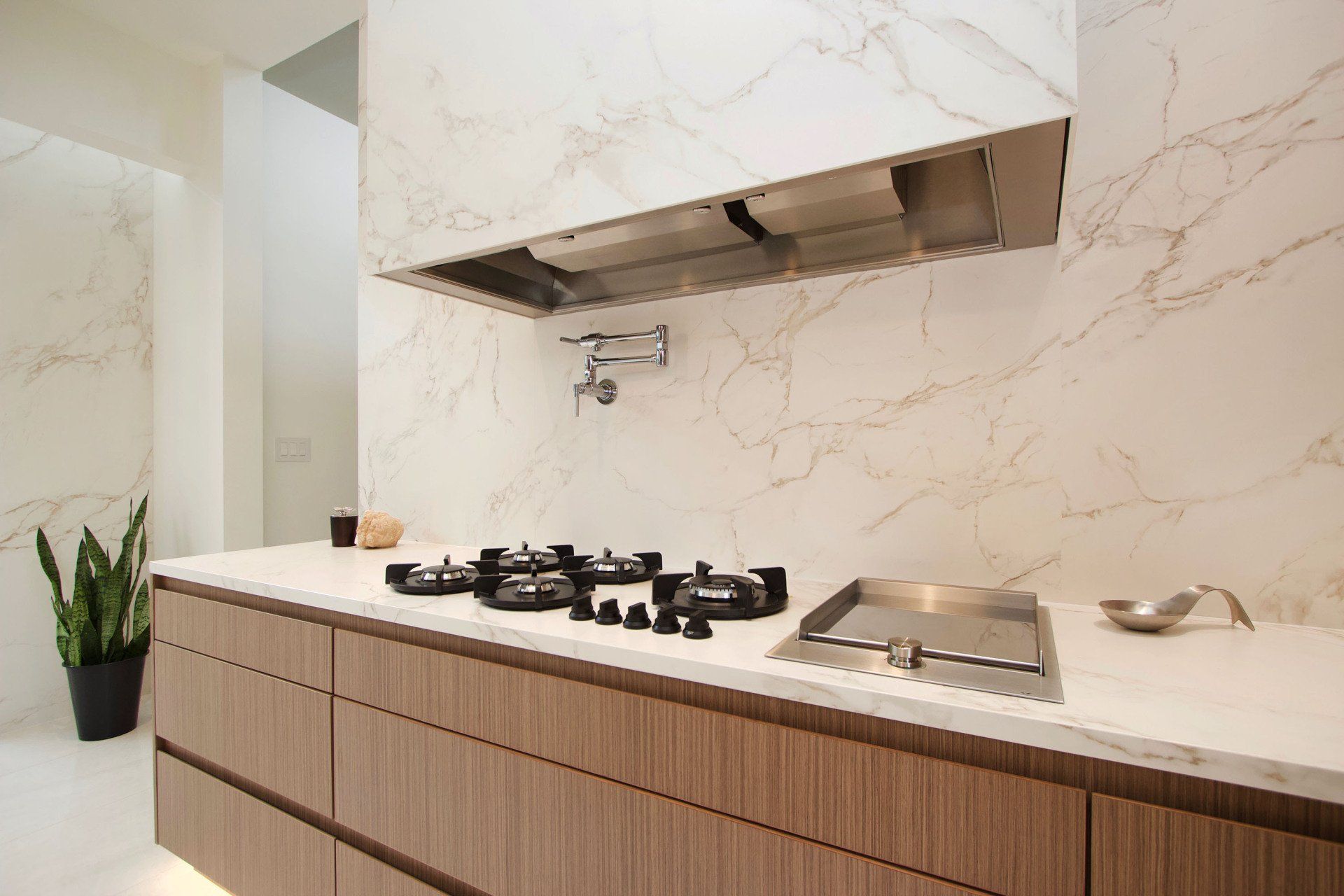 A kitchen with a stove top oven and a hood.