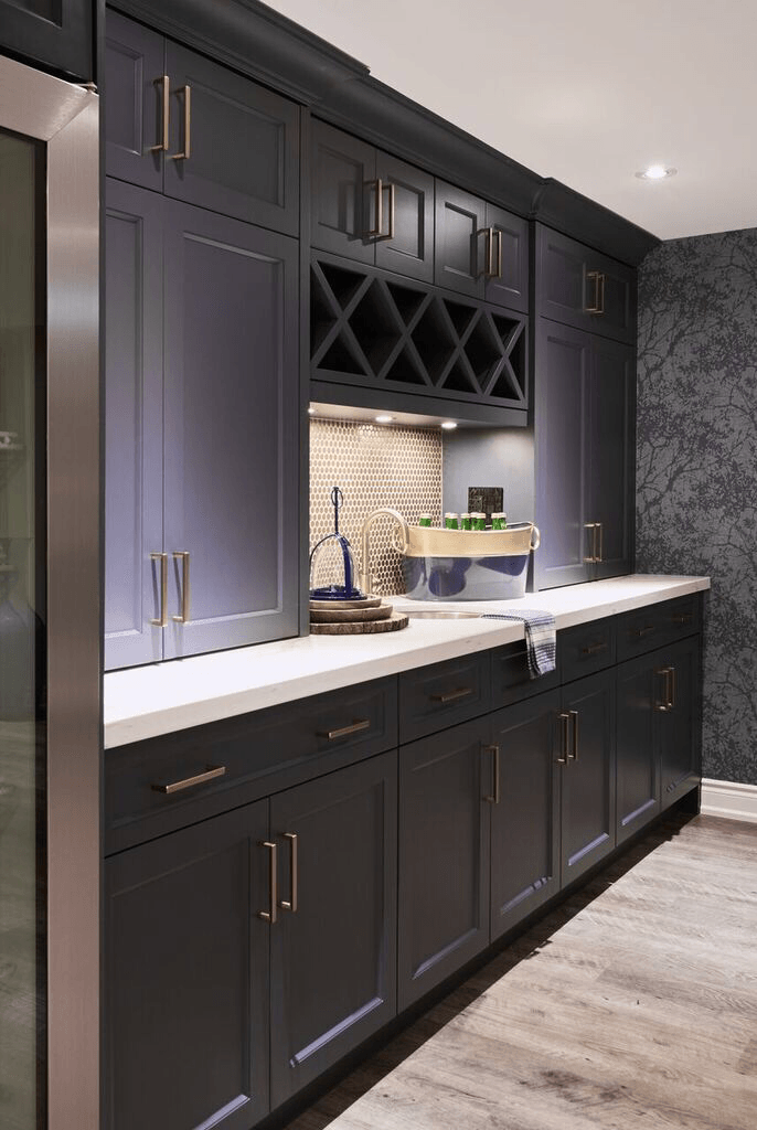 A kitchen with black cabinets and a wine rack above the sink.