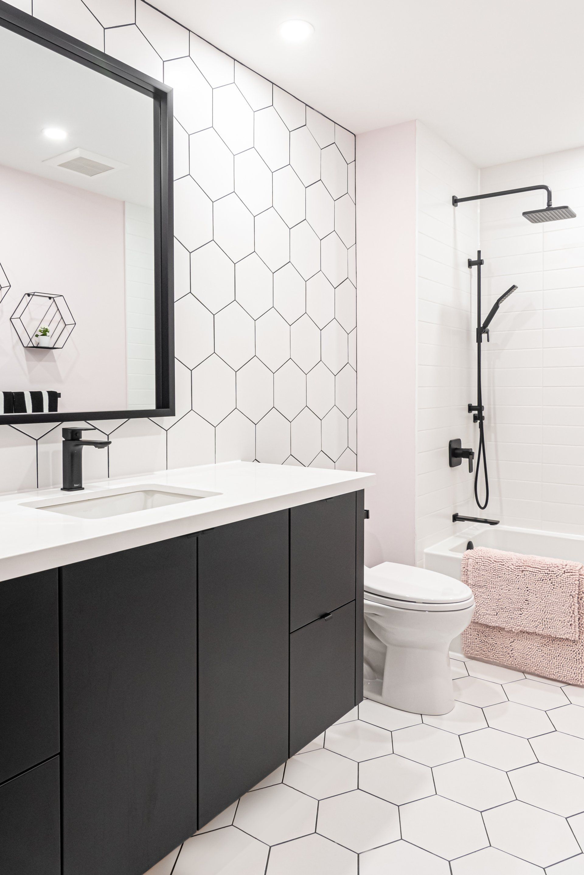 A bathroom with a toilet , sink , mirror and shower.