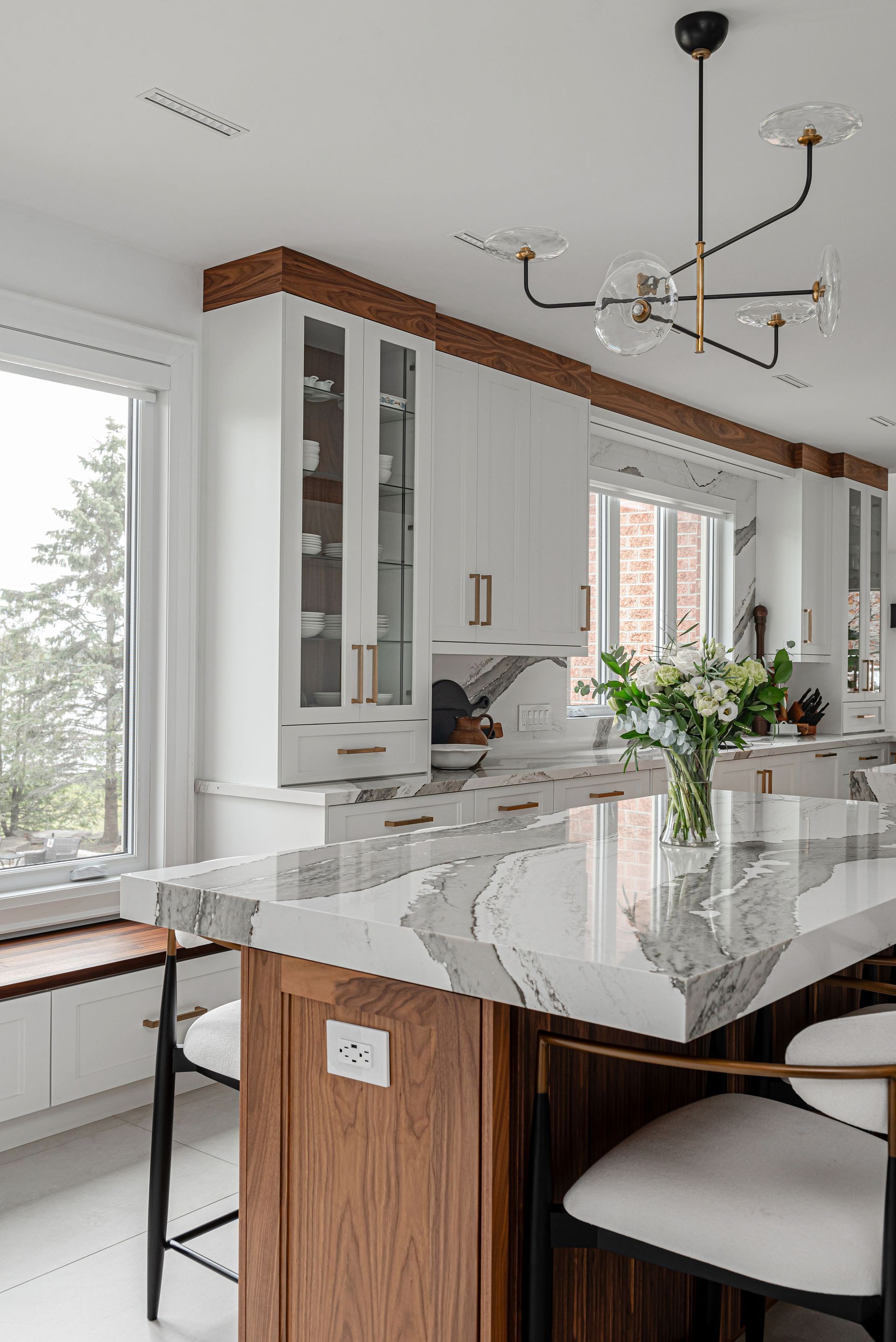 A kitchen with white cabinets and a marble counter top.