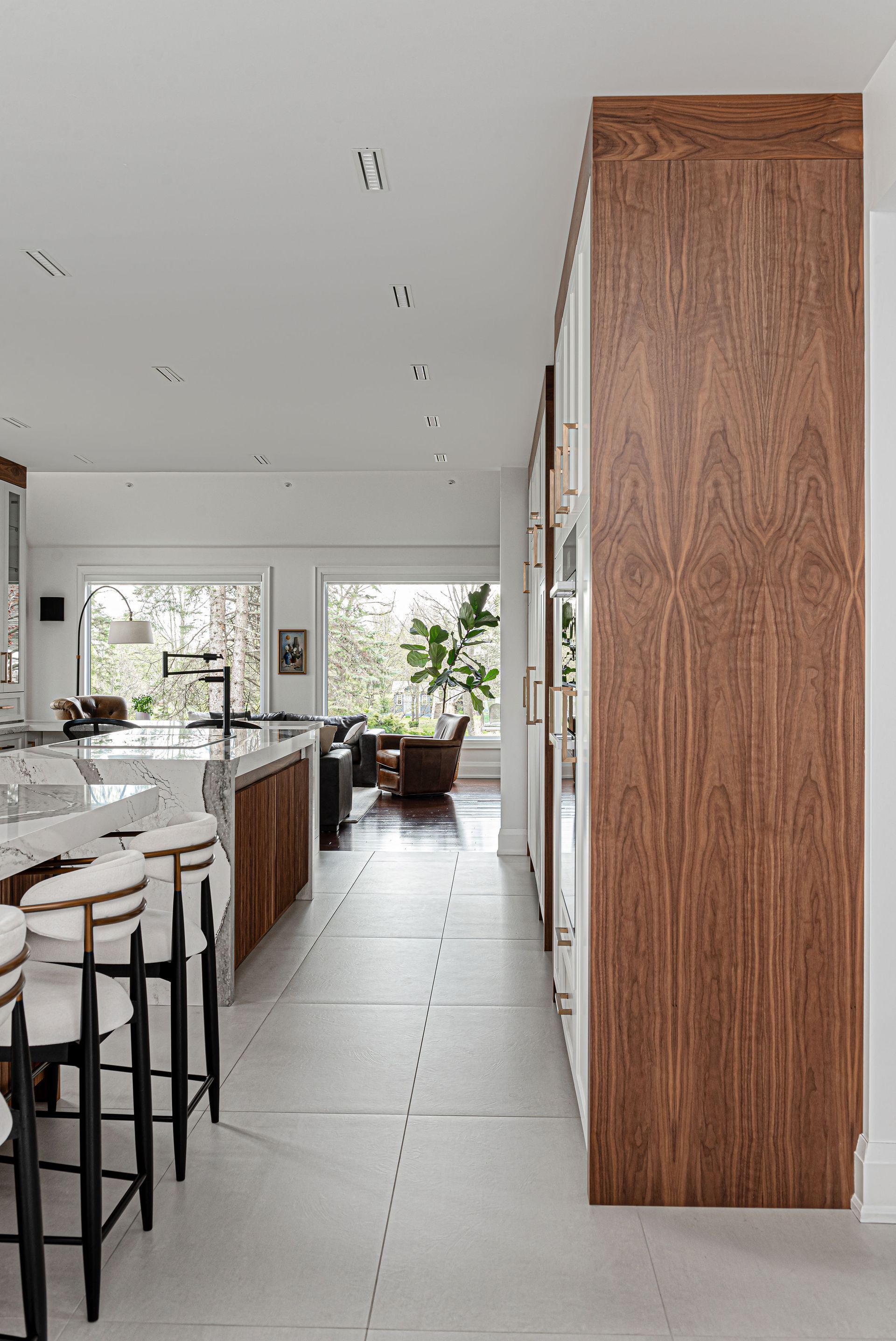 A kitchen with wooden cabinets and white counter tops and stools.