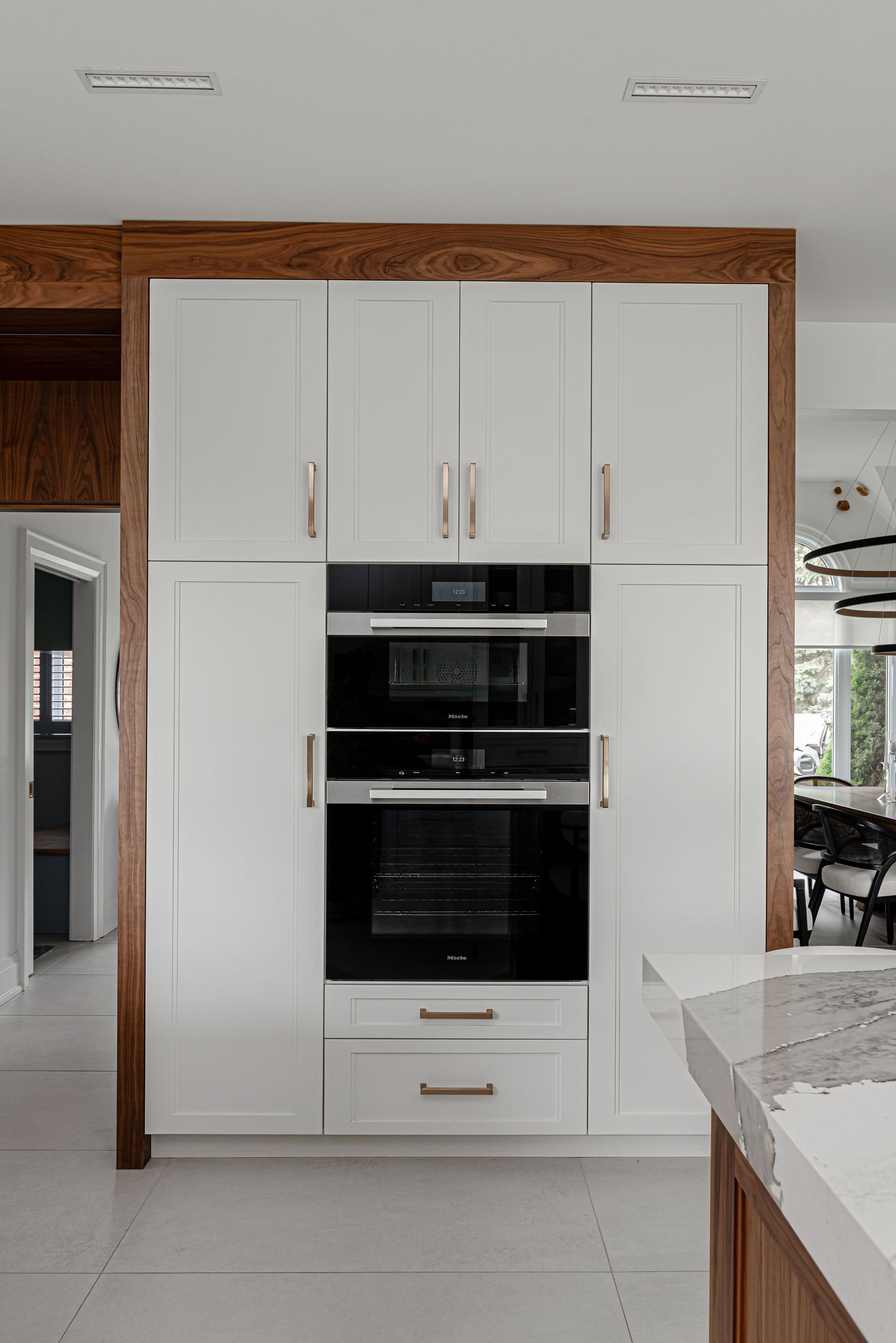 A kitchen with white cabinets and a black oven.