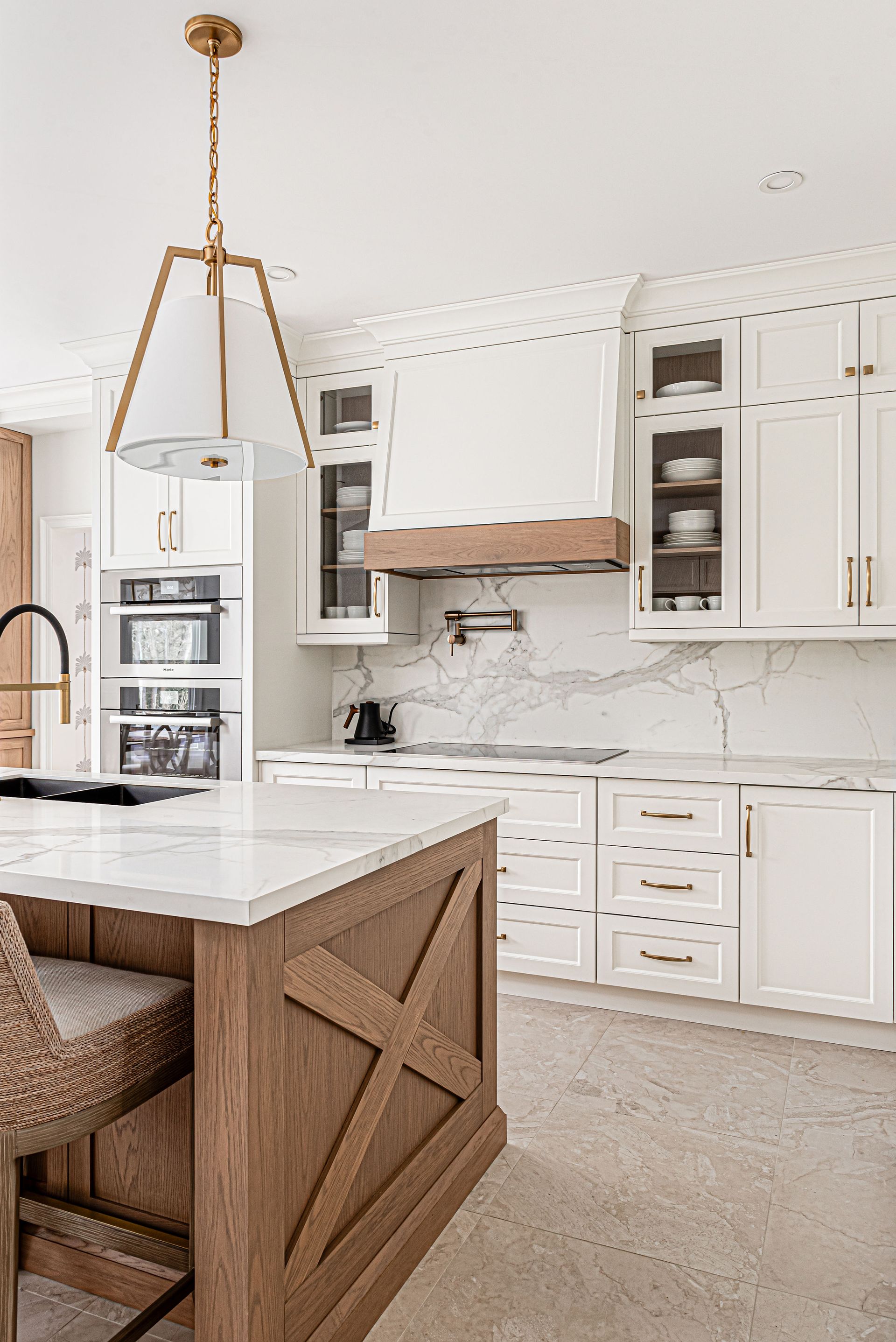 A kitchen with white cabinets and a wooden island.