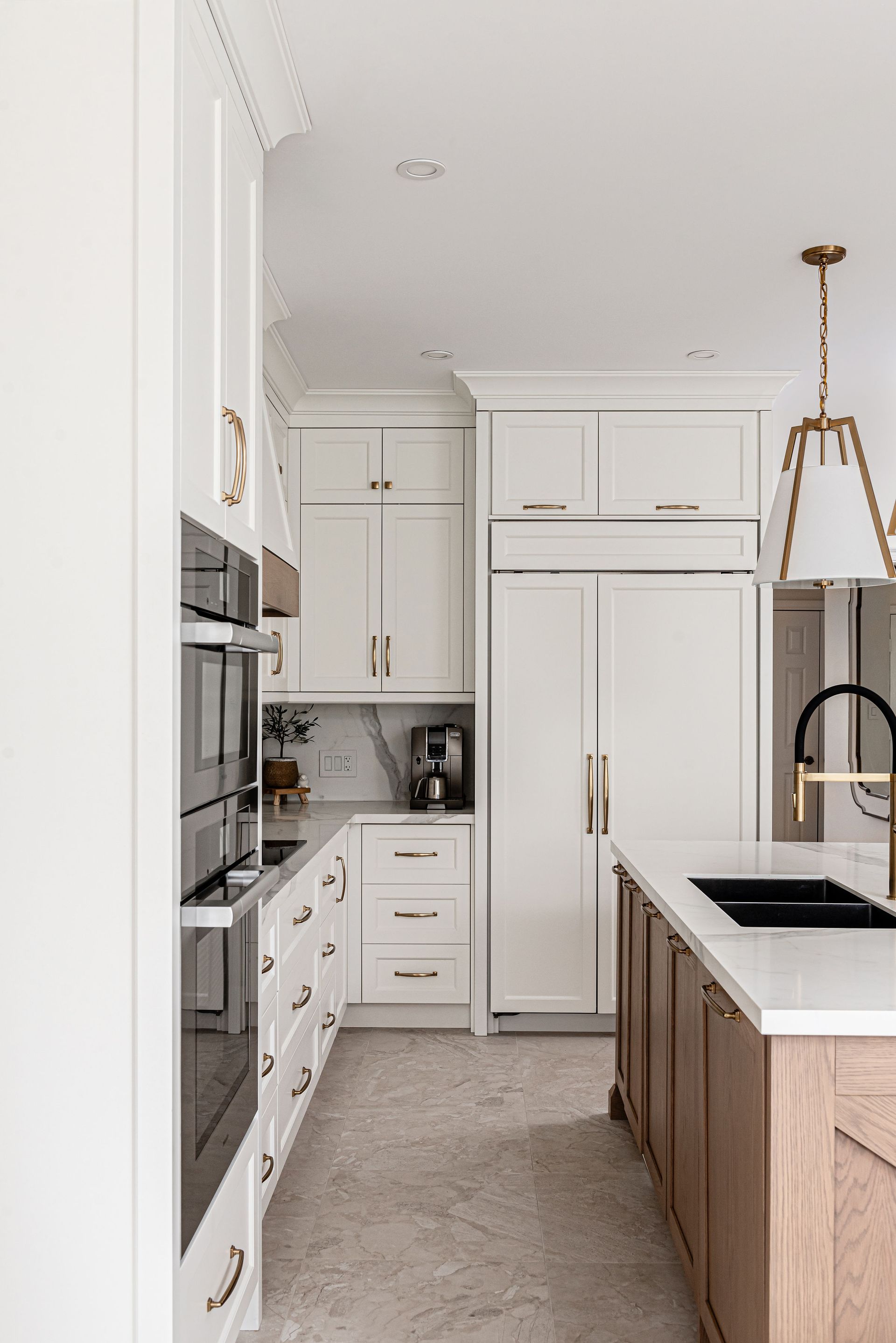 A kitchen with white cabinets , wooden cabinets , a sink , and a refrigerator freezer.