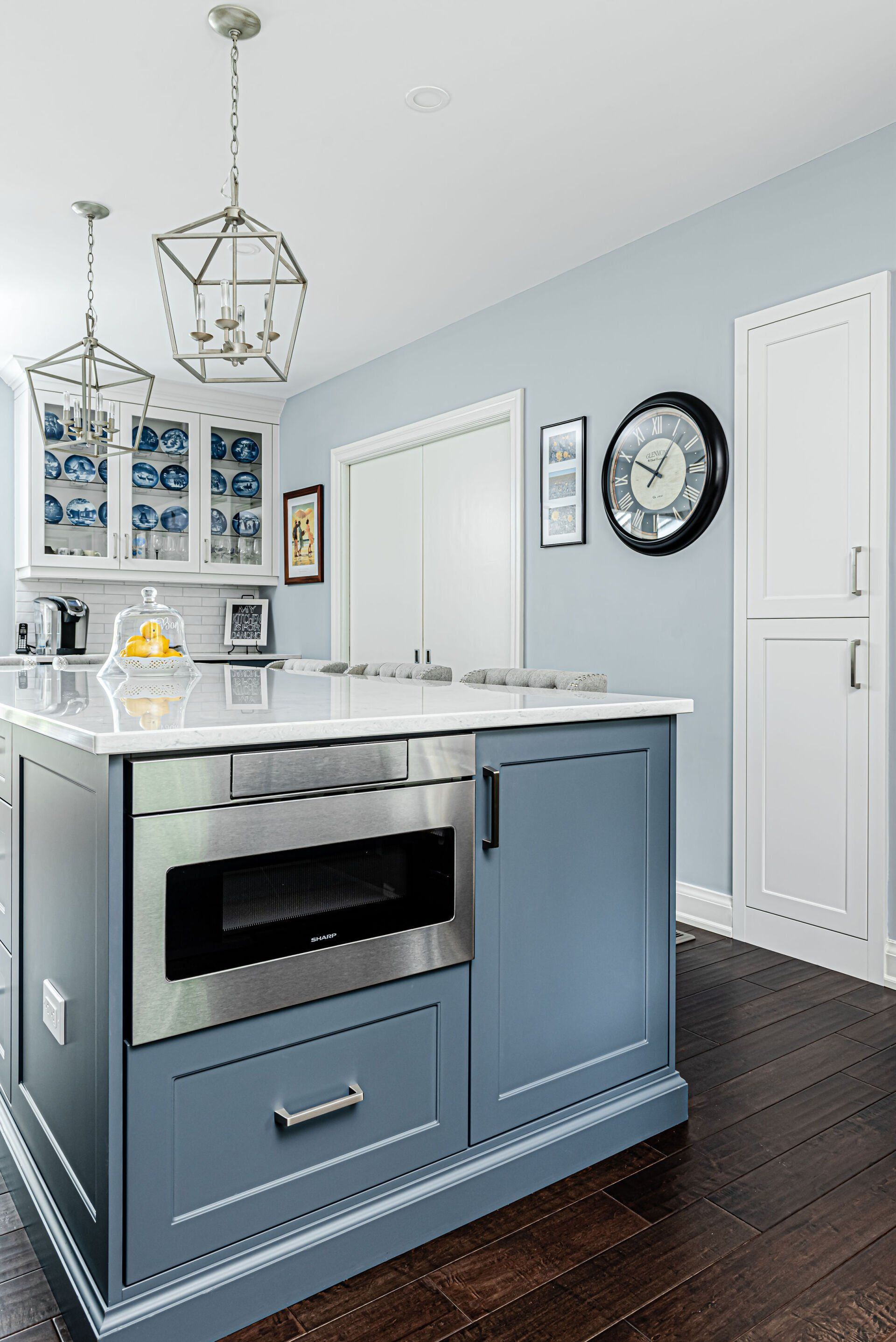 A kitchen with a large island and a stainless steel oven.