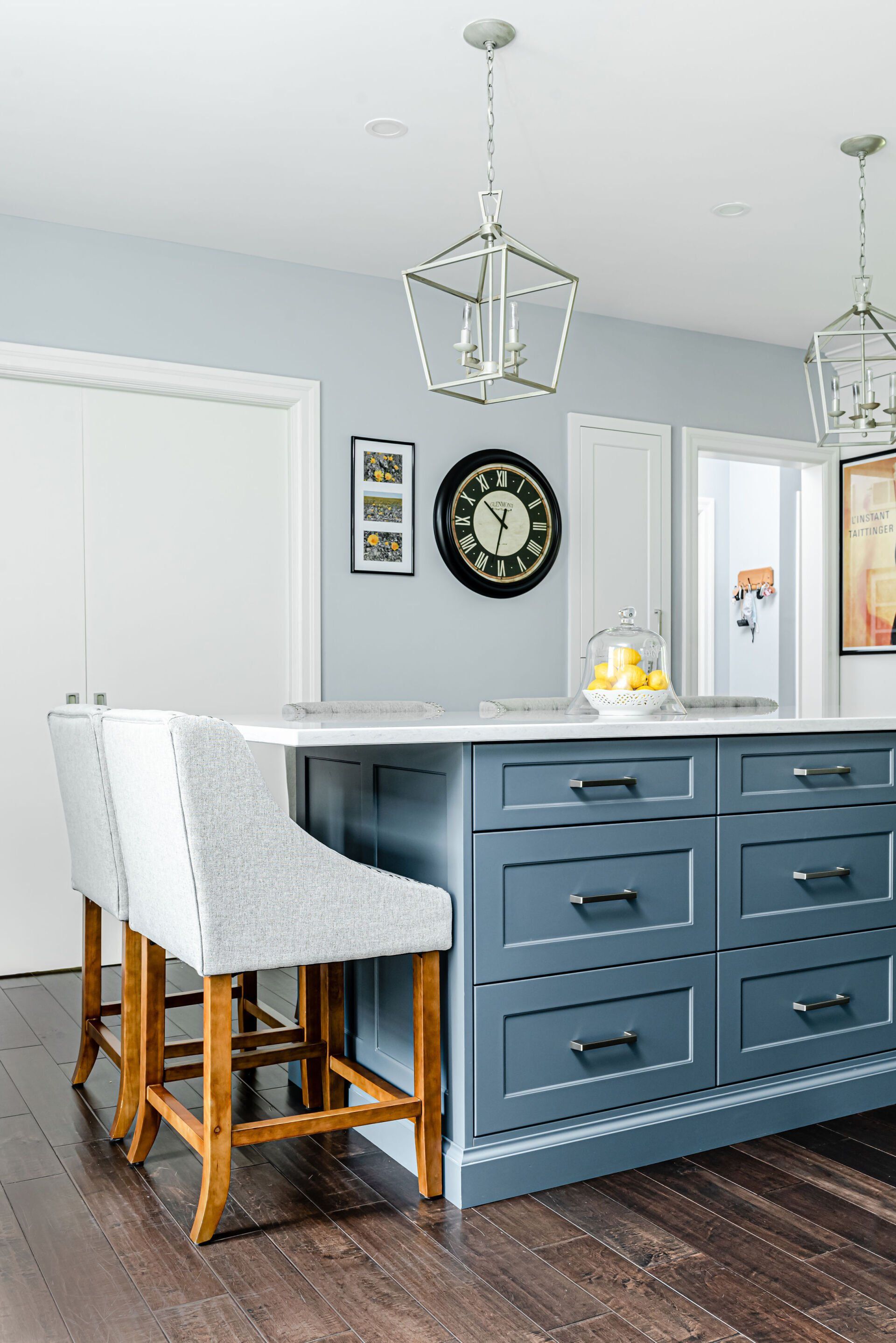 A kitchen with a large island and a clock on the wall.