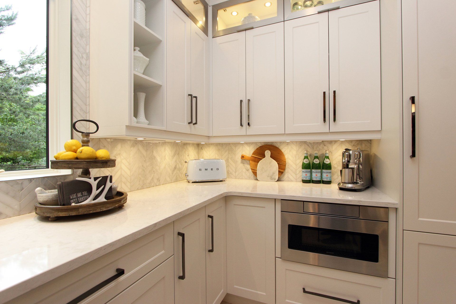 A kitchen with white cabinets and stainless steel appliances.
