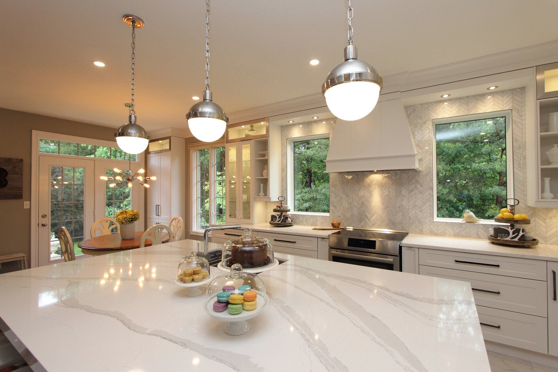 A kitchen with white cabinets and a large island in the middle