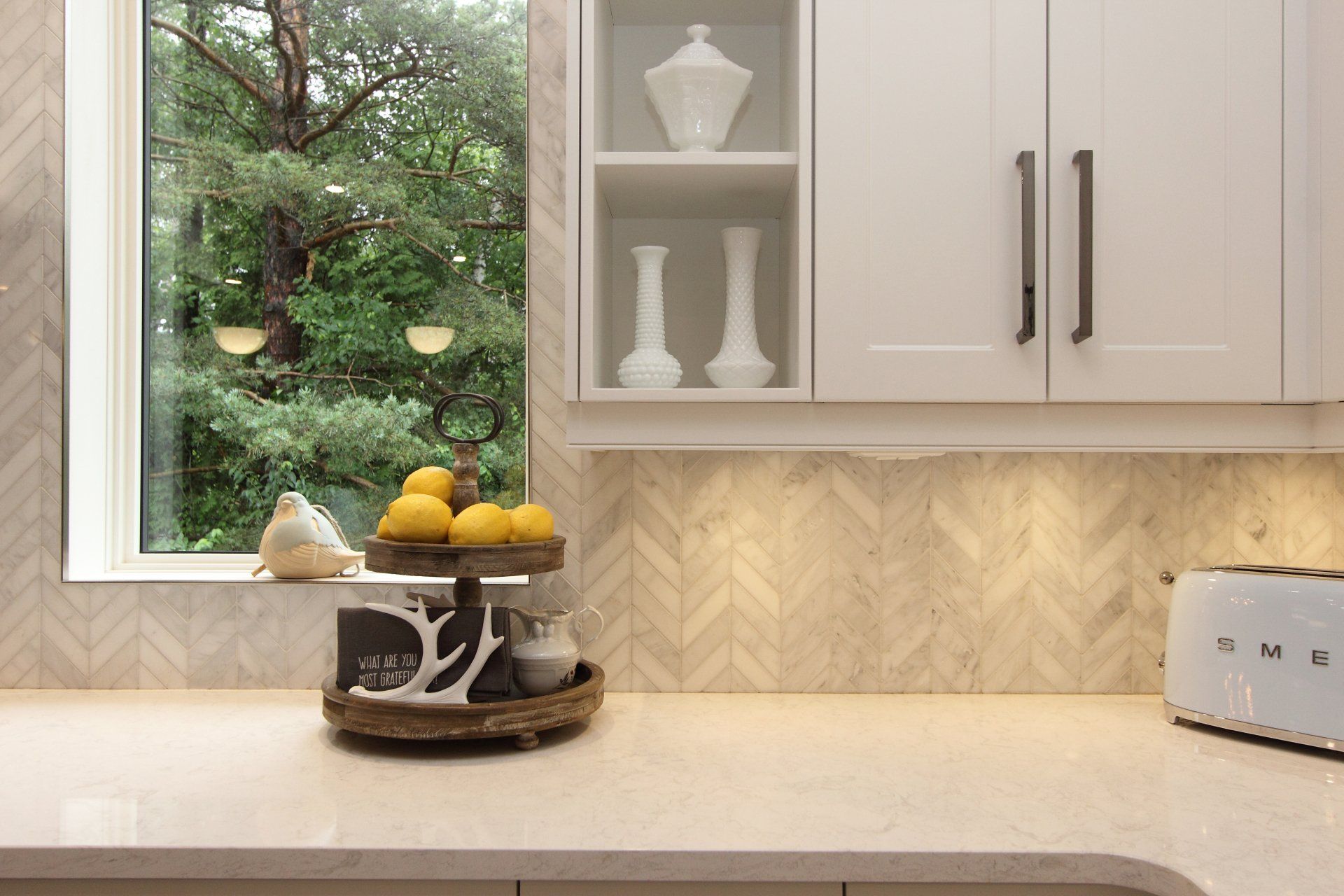 A kitchen counter with a basket of lemons and a toaster oven.