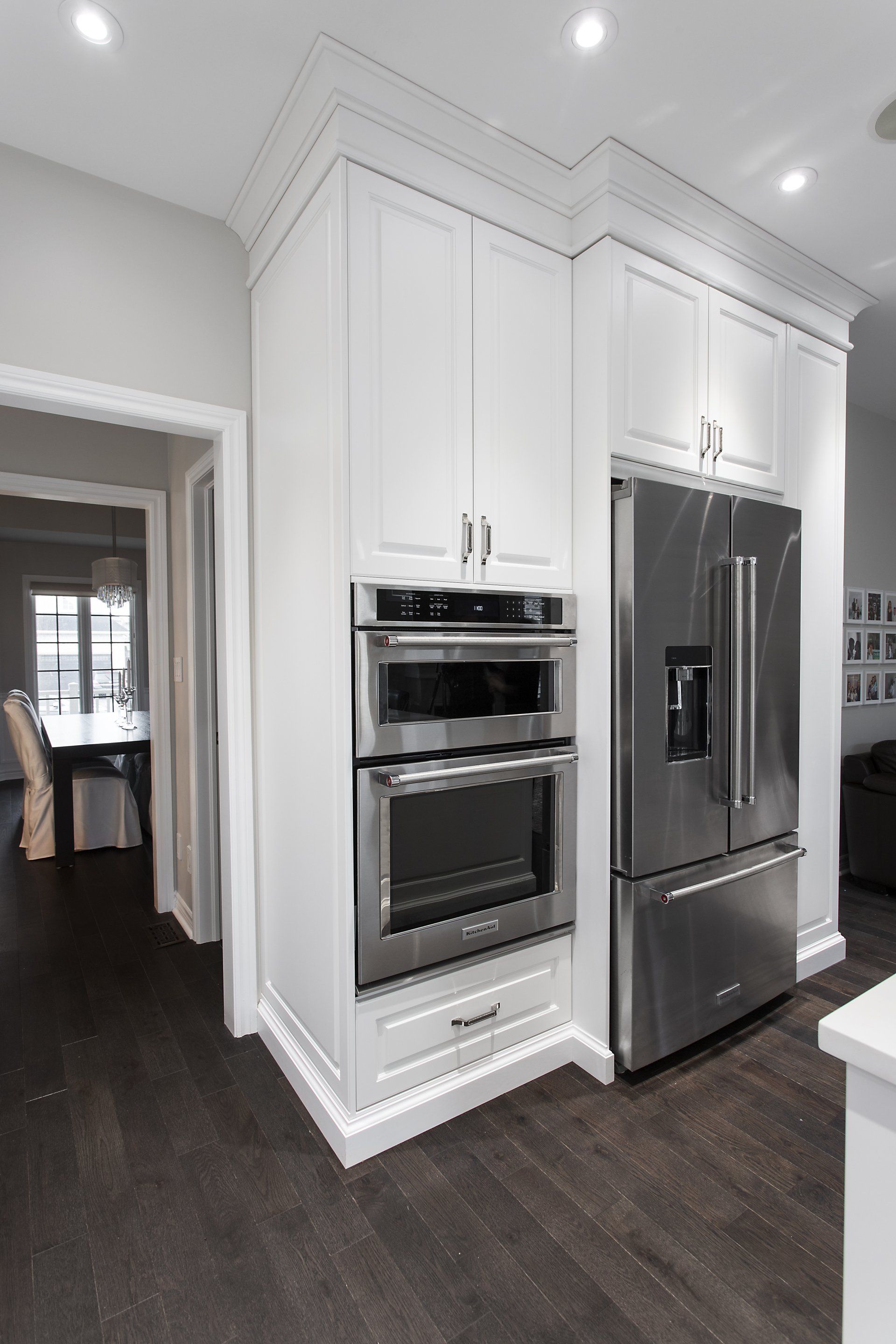 A kitchen with stainless steel appliances and white cabinets.
