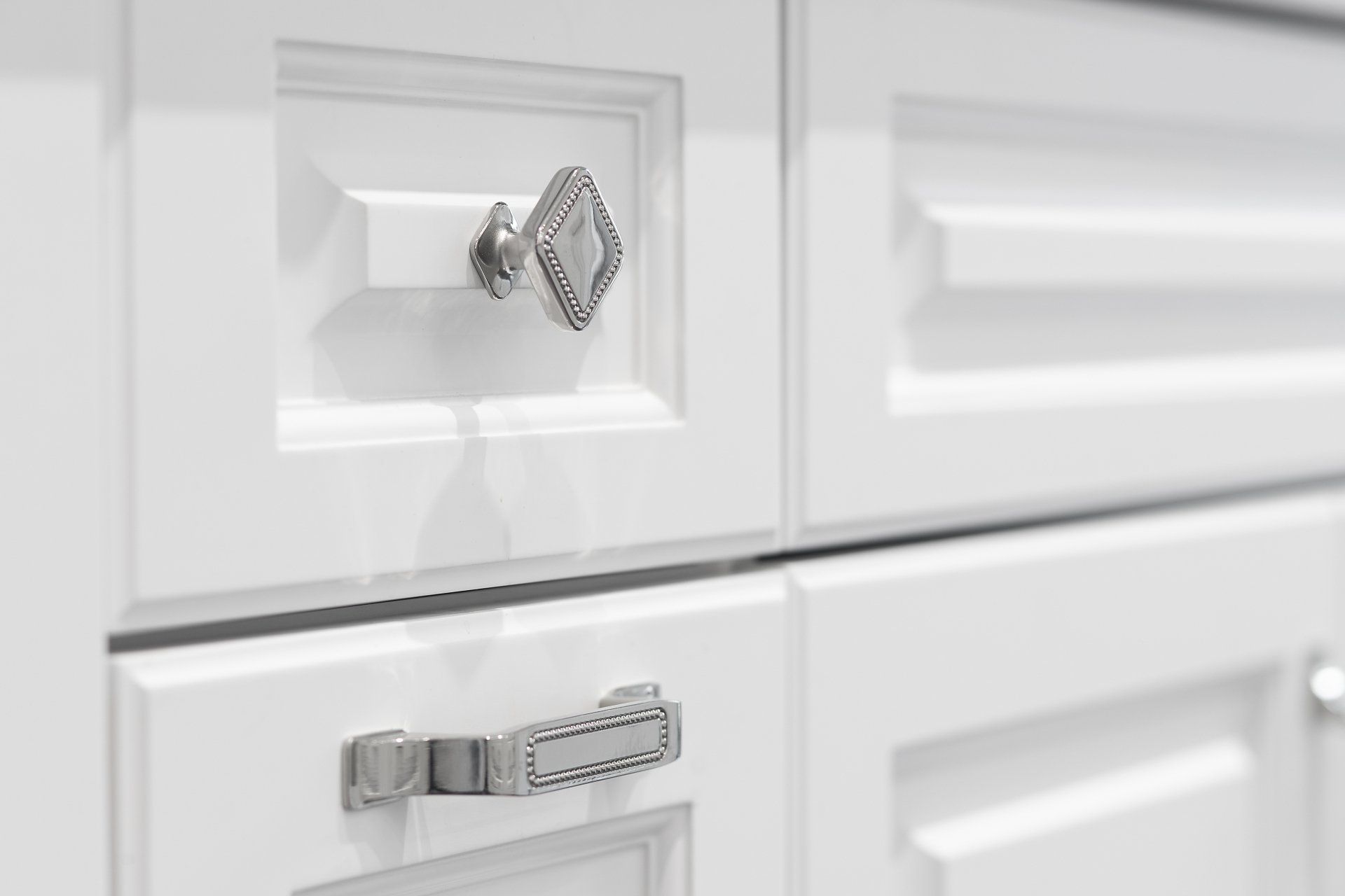 A close up of a white cabinet with a silver handle.