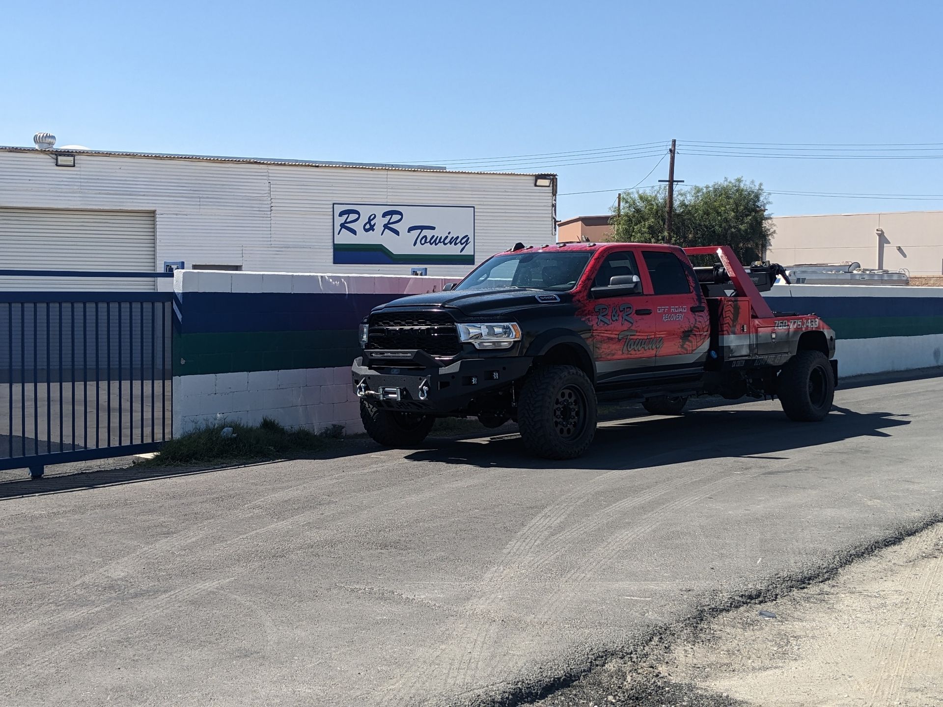 A red tow truck is parked in front of a building.
