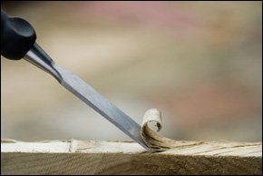 Make a difference to your home with bespoke carpentry services in Northern Ireland Carpenters chisel cutting into soft wood in Northern Ireland