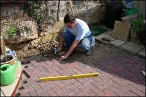 A builder laying red bricks in a home patio in Northern Ireland