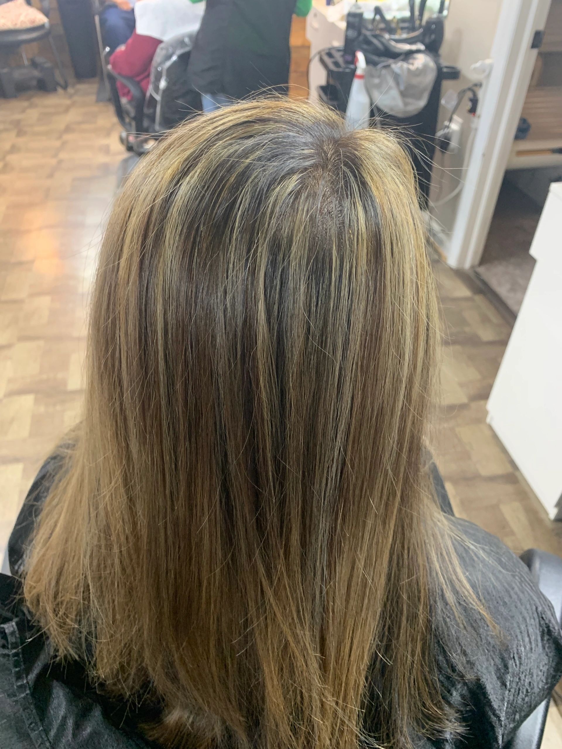 The back of a woman 's hair is shown in a salon.